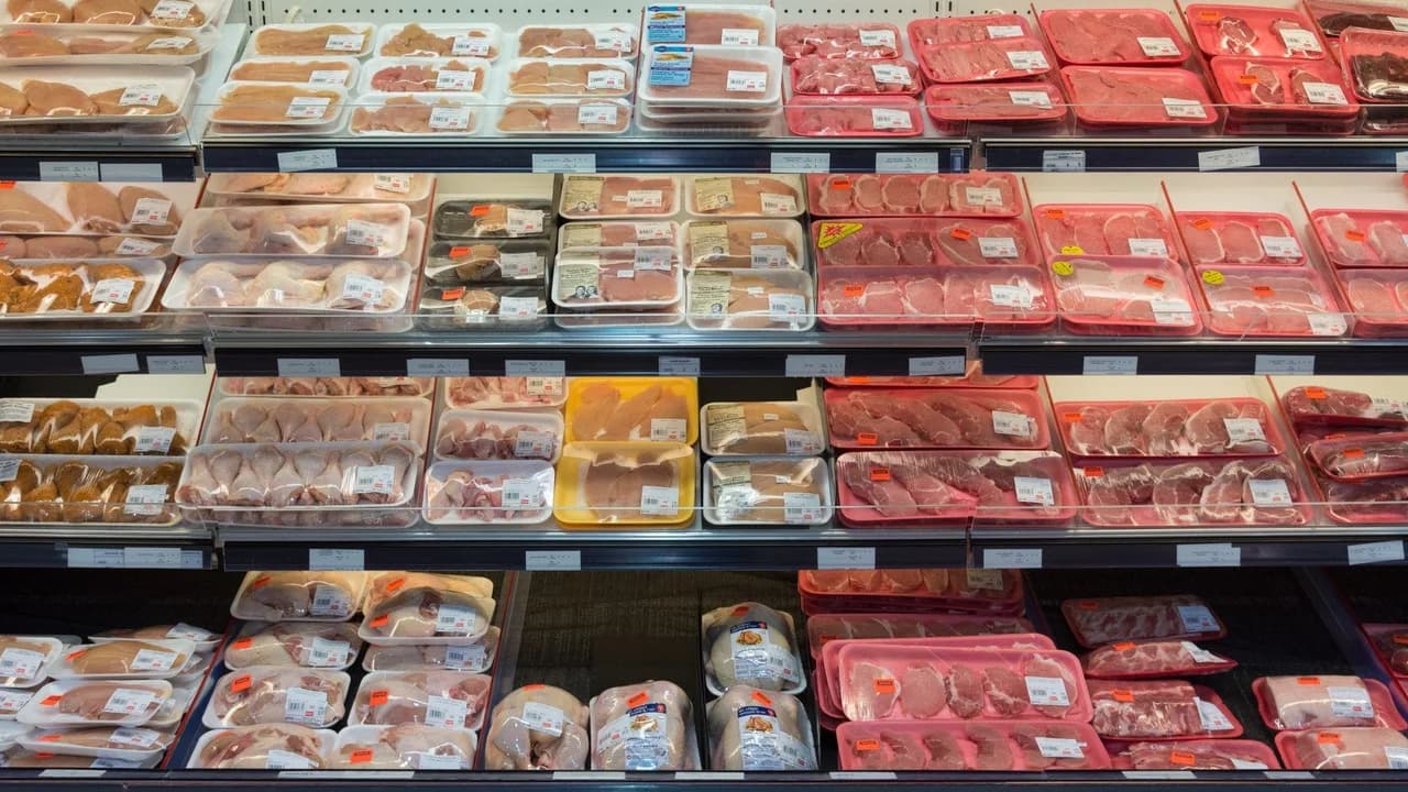 Packaged pork, beef and chicken trays laid out under the lights of a supermarket meat counter in Quebec City.