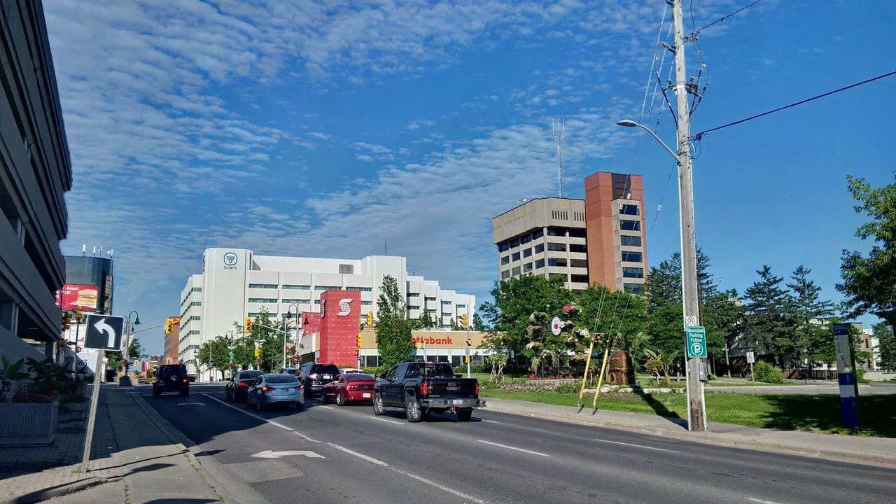 A downtown Oshawa street scene on King Street with moving cars and buildings; no people visible